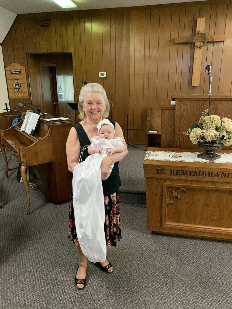 Grandmother holding the baby near the altar in the sanctuary