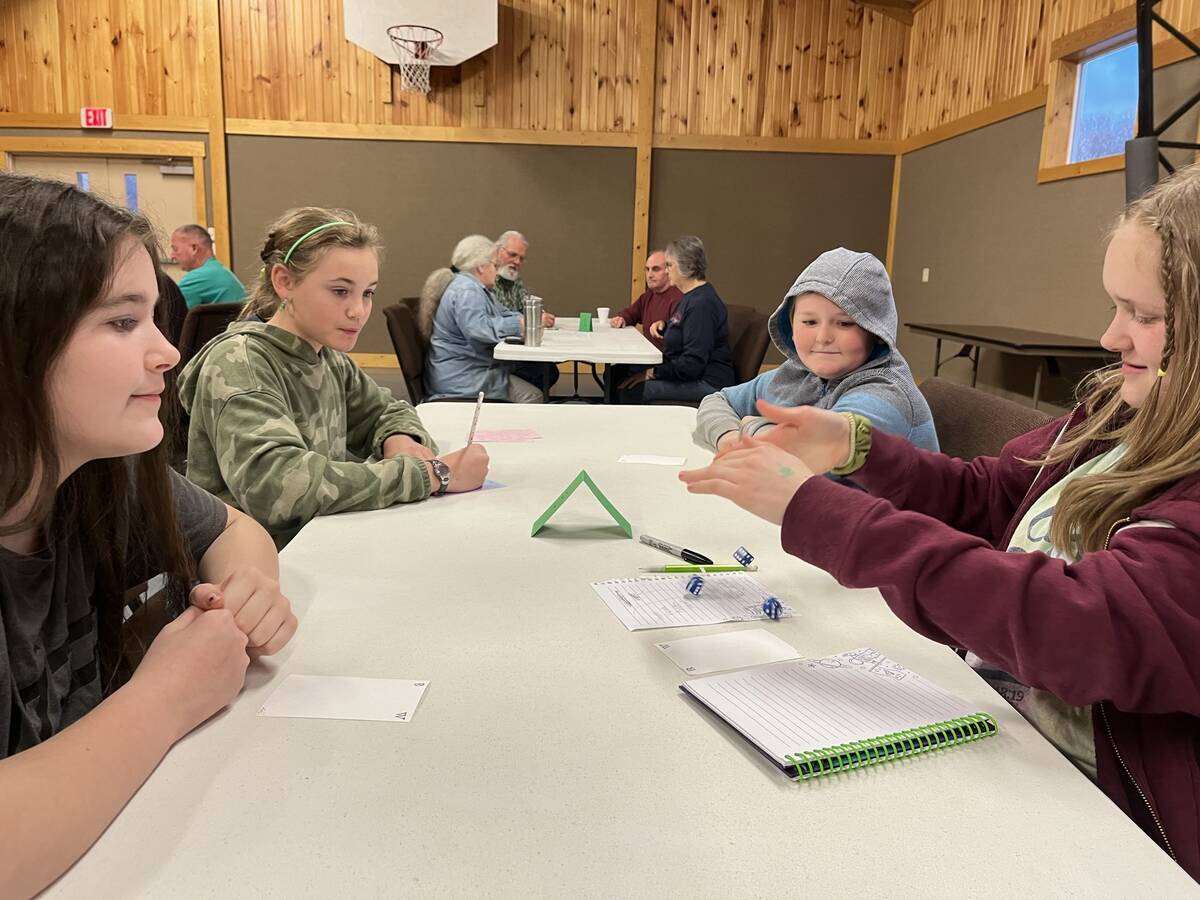 Kids and adults playing a table game together