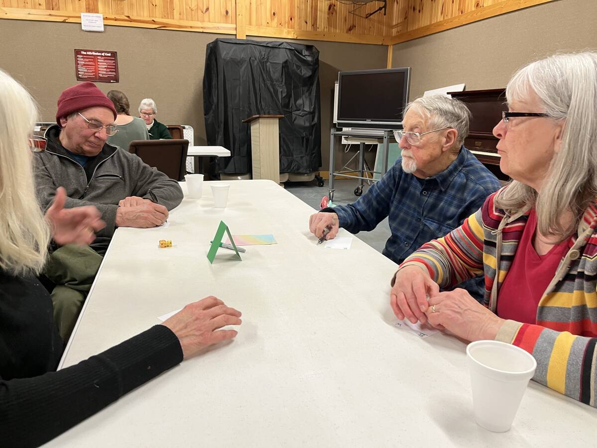 Friends laughing around a table during a game