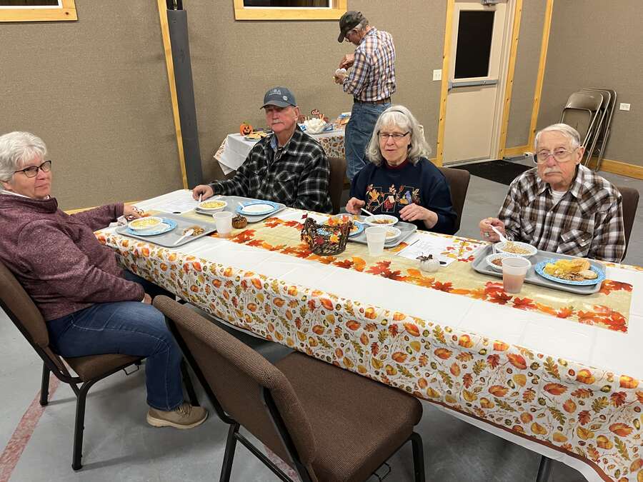Members enjoying a meal at a table with a fall tablecloth