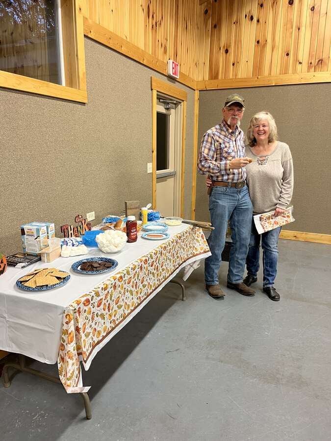 Couple standing by a dessert table at a church dinner