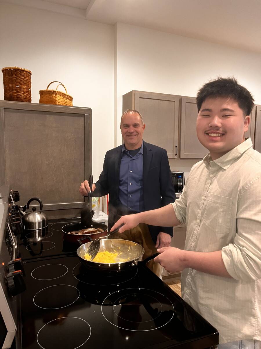 Two men cooking breakfast together in the church kitchen
