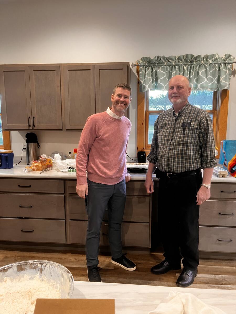 Pastor and a member standing together in the church kitchen