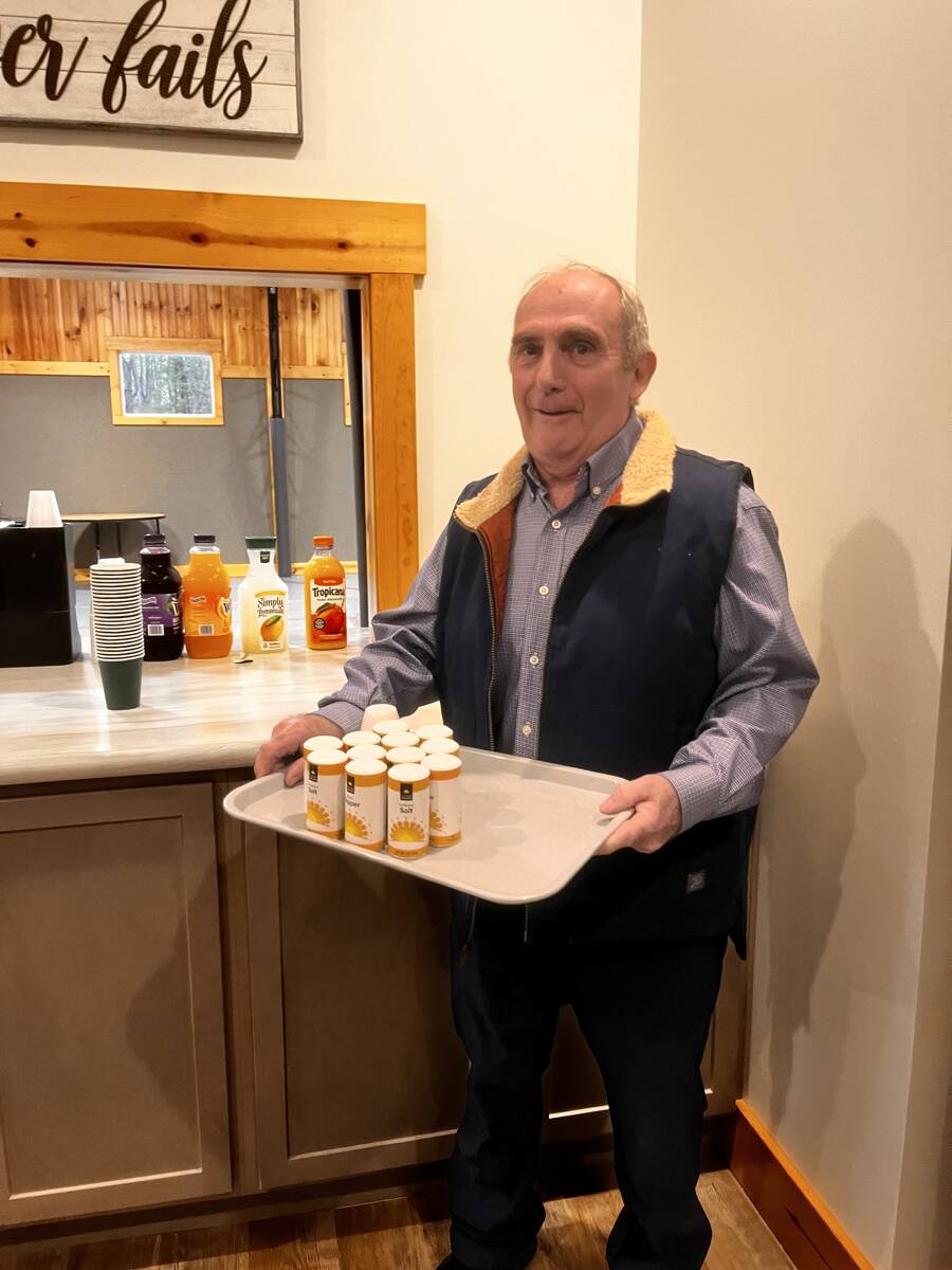 Smiling man carrying a tray of juice at breakfast