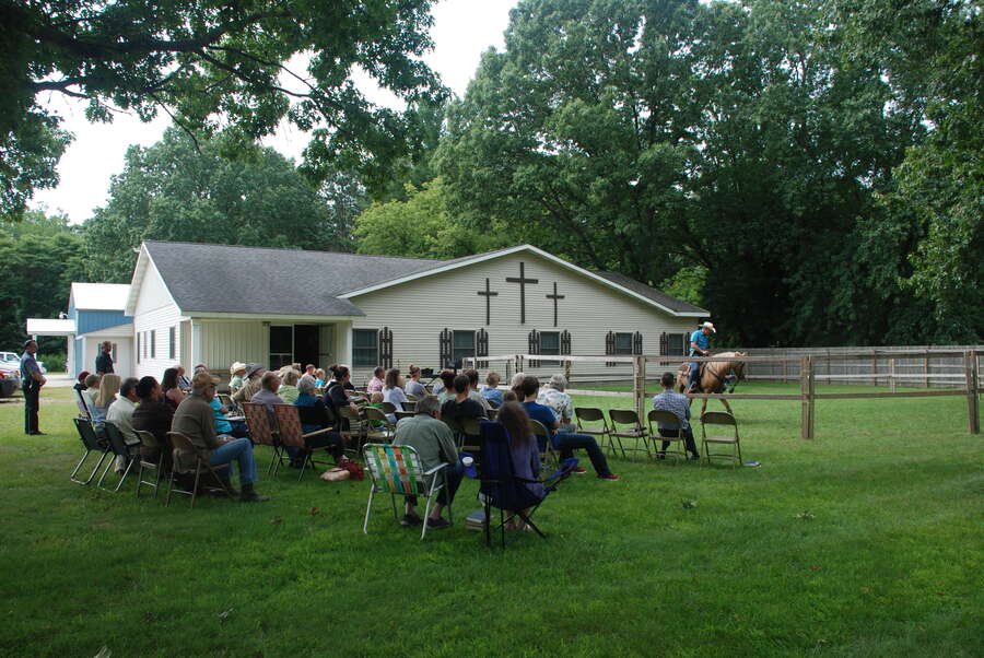 Congregation seated on the front lawn of Pullman Bible Church for an outdoor Cowboy Church service