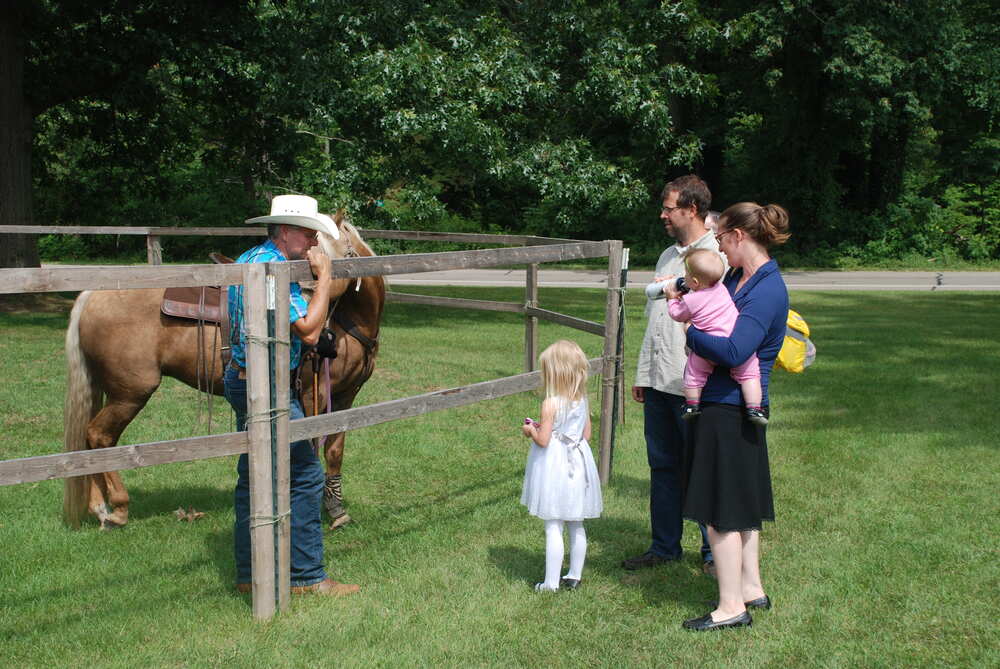 Family with young children meeting the horse at the fence